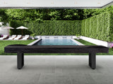 American Heritage Lanai 12' Obsidian Black shuffleboard table is set on a patio near the pool.