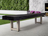 American Heritage Lanai 12' Oyster Grey shuffleboard table on patio near greenery and flowers.