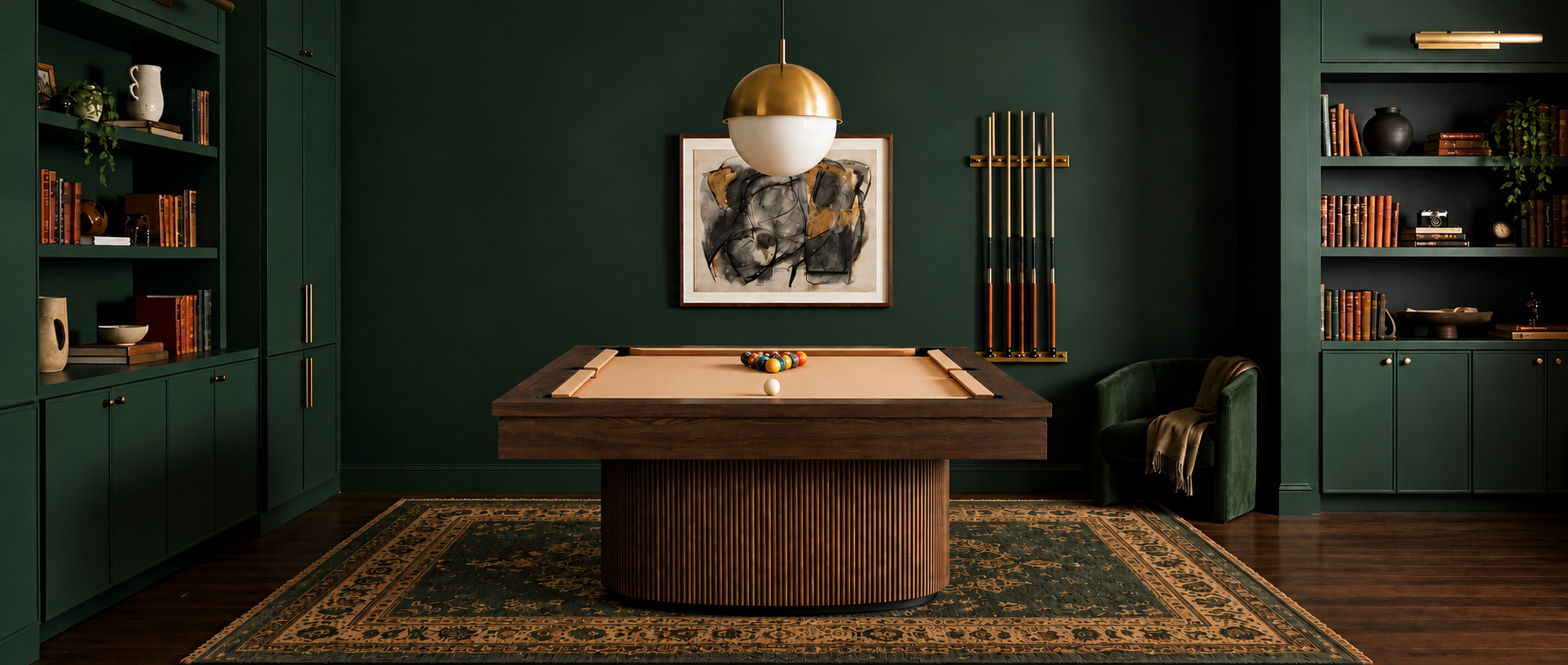 A dark wood pool table with a beige felt surface sits in a styled room with deep green walls, built-in bookshelves, a hanging gold-and-white globe light, and a patterned rug.
